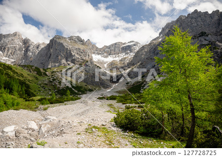 ocky alpine valley surrounded by dramatic mountain peaks in the Austrian Alps ocky alpine valley surrounded by dramatic mountain peaks in the Austrian Alps 127728725