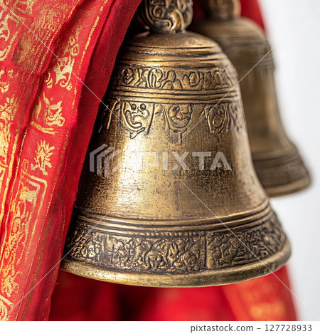 Ornate Bell with Intricate Design and Red Fabric Background 127728933