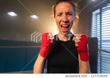 Outcry independent girl power. Angry strong crazy woman fighter screaming looking aggressive on boxing ring. Powerful ambitious victorious confident successful girl champion emotional energetic 127729049