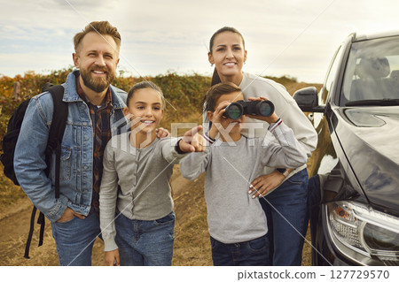 Family standing near their car during road trip vacation together on holidays. 127729570