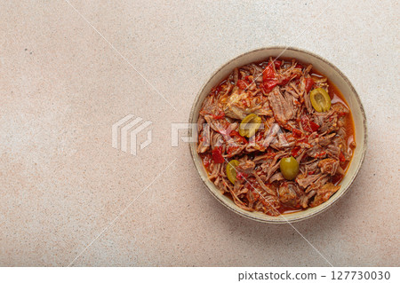 Ropa vieja with white rice, tomato sauce and green olives on a plate top view, traditional dish of Cuba, space for text Ropa vieja with white rice, tomato sauce and green olives on a plate top view, traditional dish of Cuba, space for text 127730030