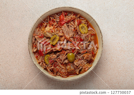Ropa vieja with white rice, tomato sauce and green olives on a plate top view, traditional dish of Cuba 127730037