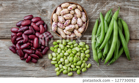 Fresh assorted beans arranged on wooden surface showcasing diverse colors and varieties ready for cooking or healthy eating experiences Fresh assorted beans arranged on wooden surface showcasing diverse colors and varieties ready for cooking or healthy eating experiences 127730092