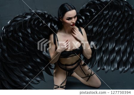 Elegance and allure of a woman in lingerie with striking black wings Elegance and allure of a woman in lingerie with striking black wings 127730394