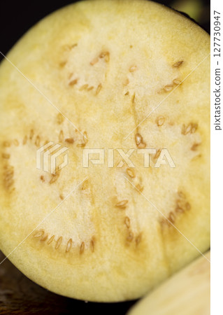 ripe eggplant sliced with seeds inside, ripe purple delicious eggplant sliced on the kitchen table, close up 127730947