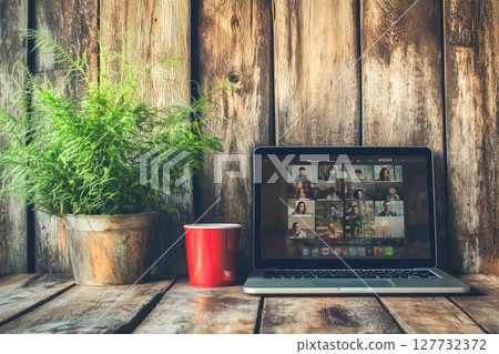Diverse Employees Engaged in Online Video Conference on Laptop in Cozy Workspace Setting 127732372