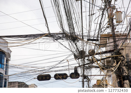 Chaotic overhead power lines and tangled cables for concepts of infrastructure problems, urban overload, or communication failure 127732430