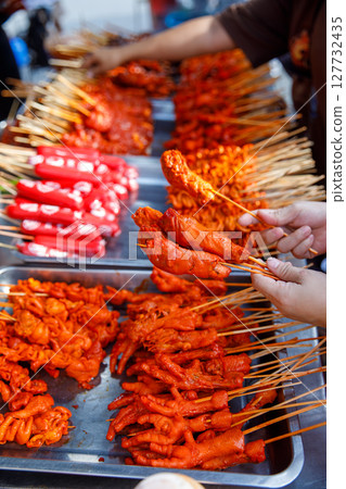 Philippine street food skewers with grilled chicken feet and local delicacies, perfect for travel blogs, food menus, or culinary marketing 127732435