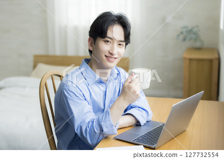 A young man using a computer A young man using a computer 127732554