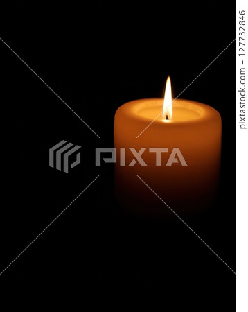 Single burning candle illuminating the darkness 127732846