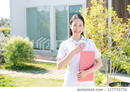 A female nurse smiling in front of a building A female nurse smiling in front of a building 127733750