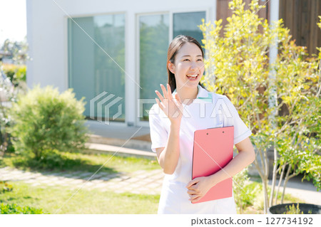 A female nurse smiling in front of a building 127734192