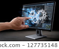 A hand interacts with a computer screen displaying gears and elements of industrial design. The workspace reflects innovation and technological advancement. 127735148
