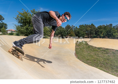 Skateboarder on a pump track park Skateboarder on a pump track park 127737482