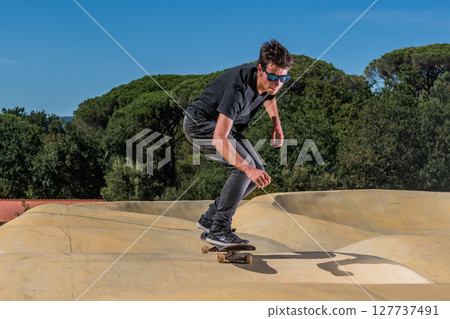 Skateboarder on a pump track park Skateboarder on a pump track park 127737491