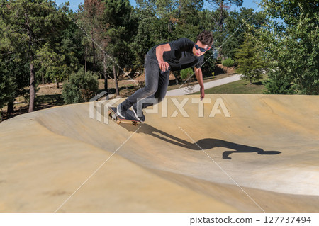 Skateboarder on a pump track park Skateboarder on a pump track park 127737494