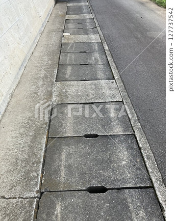 人行道排水溝蓋和混凝土紋理 人行道排水溝蓋和混凝土紋理 127737542