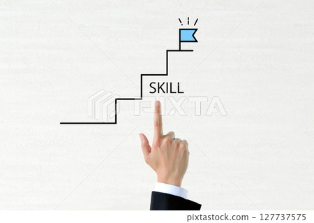 A businessman's hand pointing at a staircase symbolizing skill improvement 127737575