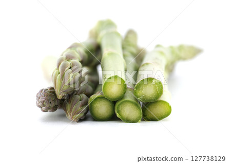 Close-up of fresh green asparagus on a white background, ready to be cooked. 127738129