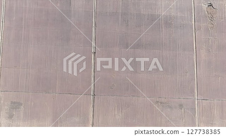 Weathered Gray Concrete Wall with Visible Seams and Minor Damage 127738385