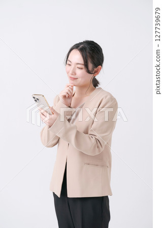 有一套衣服的一名婦女與智能手機 有一套衣服的一名婦女與智能手機 127739679