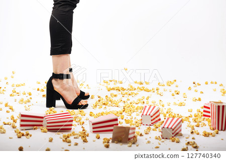 Many popcorn on floor and woman legs background 127740340