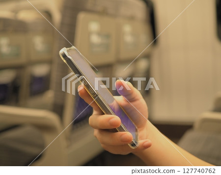 一名男子在新幹線列車上看智慧型手機 127740762