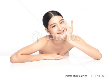 A beautiful young Asian woman with clean, fresh skin against a white background. Skincare, facial treatment, cosmetology, beauty, and spa. An elegant portrait of an Asian woman. 127741890