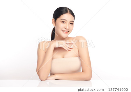 A beautiful young Asian woman with clean, fresh skin against a white background. Skincare, facial treatment, cosmetology, beauty, and spa. An elegant portrait of an Asian woman. 127741900