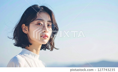 Portrait of a young woman standing by the sea 127743235