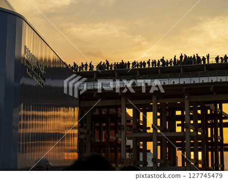 EXPO2025 People watching the sunset from the large roof ring EXPO2025 People watching the sunset from the large roof ring 127745479