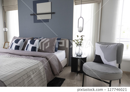 Stylish Bedroom in blue and white tone pillows setting. Cozy bedroom with art wall. Stylish Bedroom in blue and white tone pillows setting. Cozy bedroom with art wall. 127746021