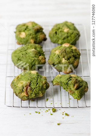 Closeup of fresh baked matcha cookies on white wooden background. Closeup of fresh baked matcha cookies on white wooden background. 127746060