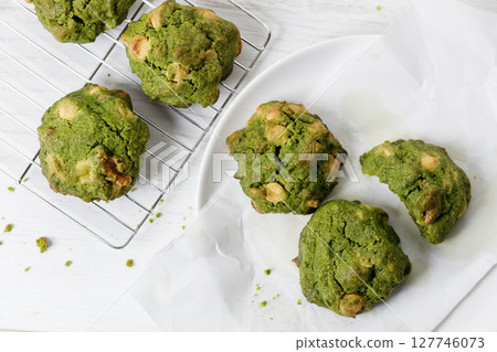 Closeup of fresh baked matcha cookies on white wooden background. 127746073