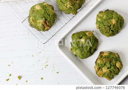 Closeup of fresh baked matcha cookies on white wooden background. Closeup of fresh baked matcha cookies on white wooden background. 127746076