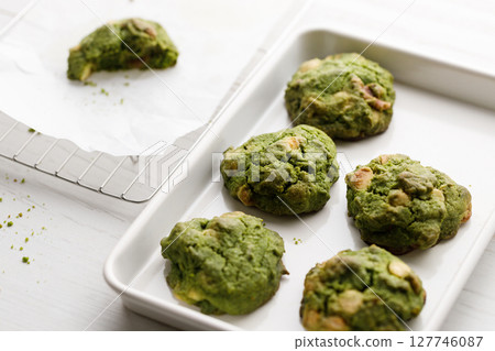 Closeup of fresh baked matcha cookies on white wooden background. Closeup of fresh baked matcha cookies on white wooden background. 127746087