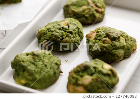 Closeup of fresh baked matcha cookies on white wooden background. 127746088