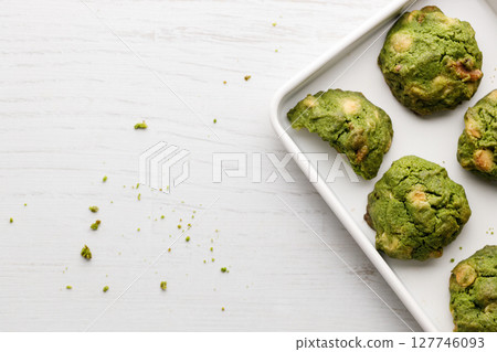 Closeup of fresh baked matcha cookies on white wooden background. 127746093