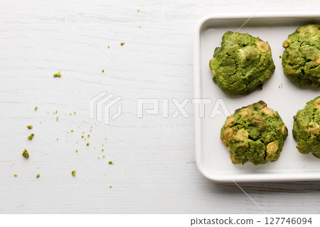 Closeup of fresh baked matcha cookies on white wooden background. 127746094