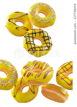 Donuts with yellow lemon glaze, sprinkles, white drizzle, and dots isolated on white transparent background 127746835