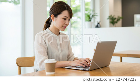 一個女人在一家咖啡館的計算機上工作 127747222