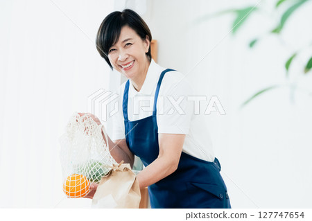 一位女家政人員正在餐桌上擺放食材 127747654