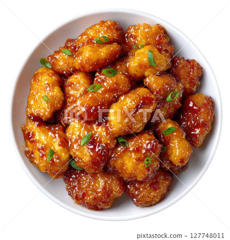 Delicious Orange Chicken Dish with Tender Bites and Glossy Sauce Garnished with Green Onions 127748011
