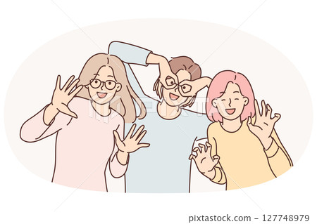 Happy girls of friend have fun making funny faces and putting fingers to faces instead of glasses Happy girls of friend have fun making funny faces and putting fingers to faces instead of glasses 127748979
