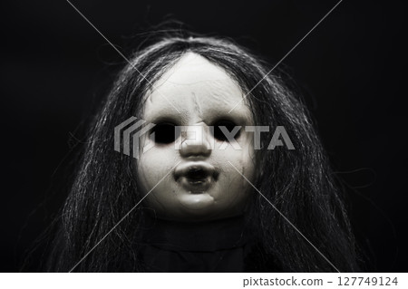 Scary doll face on dark background 127749124