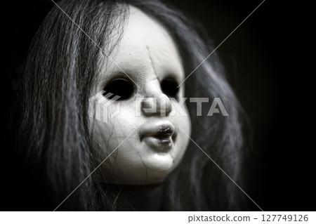 Scary doll face on dark background 127749126