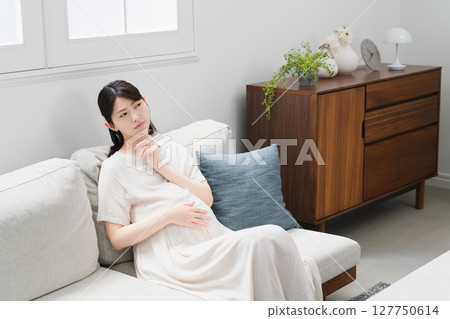 Pregnant woman relaxing on the sofa lifestyle image 127750614