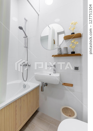 Modern Small Bathroom with Bathtub and Round Mirror 127751304