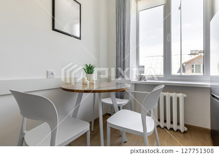 Cozy Dining Corner with Round Table and Window Light 127751308