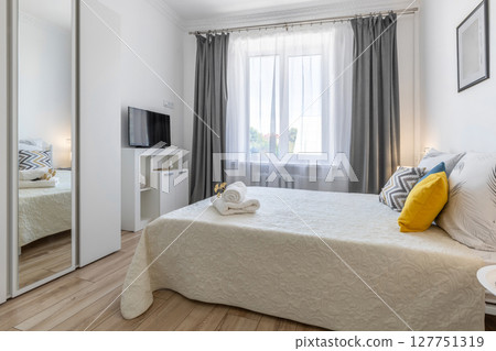 Bright Modern Bedroom with TV, Mirror and Decorated Bed Bright Modern Bedroom with TV, Mirror and Decorated Bed 127751319